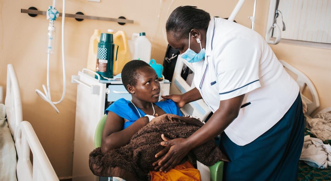 A nurse helps a young mother position her baby for breastfeeding at Kapenguria Hospital, Kenya.