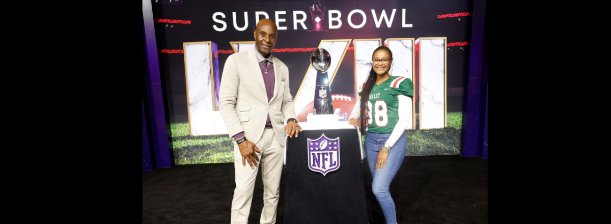 Two people stood near the super bowl trophy 