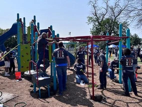 Volunteers working on the jungle jim in the playground.