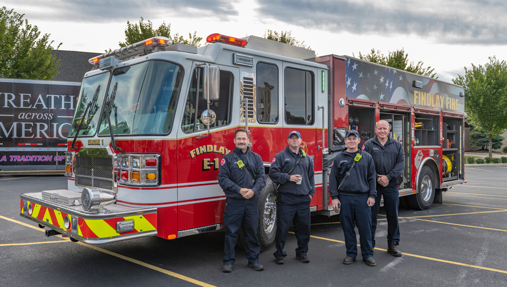 A group of firefighters in front of a fire truck "Findlay Fire" on the side
