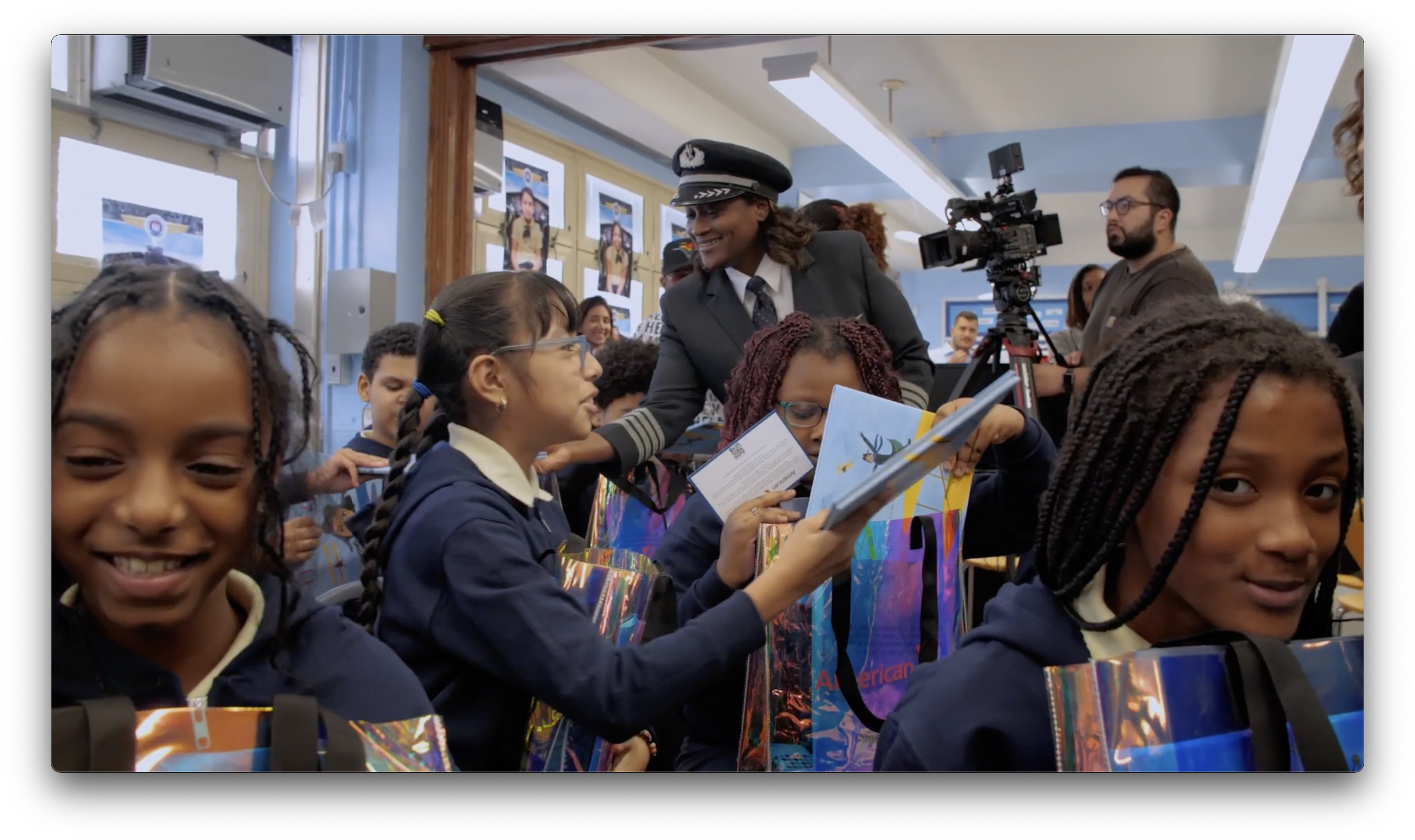American Airlines pilot speaking with a group of children holding the Bessie Coleman doll 
