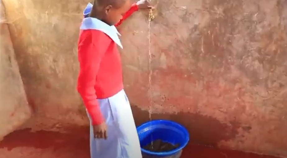 Young girl turning water on from a spigot