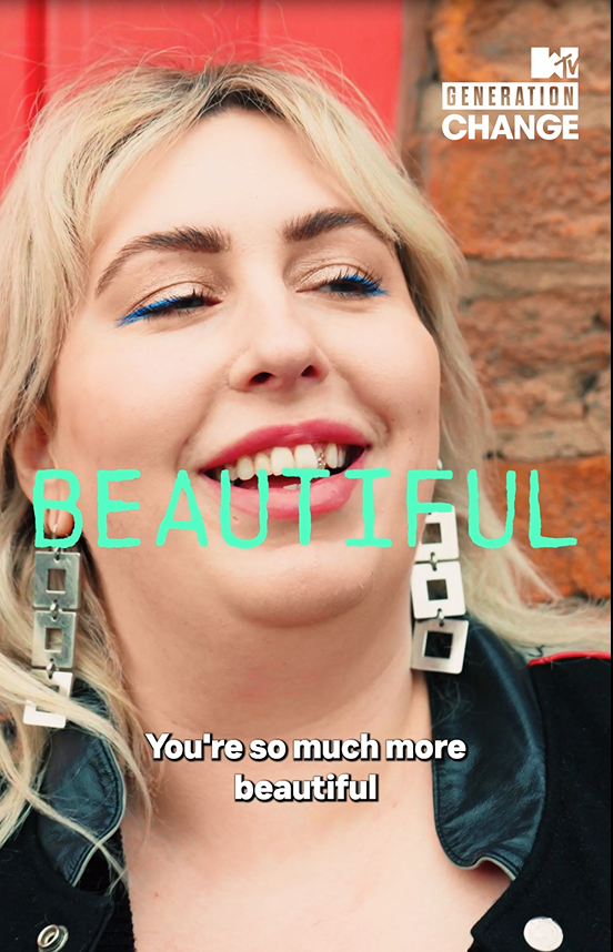 Gina Tonic outside, smiling, leaning on a brick wall. "Beautiful" in green letters on top.