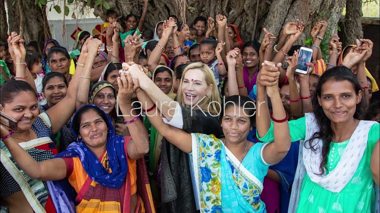 Laura Kohler holding raised hands with women