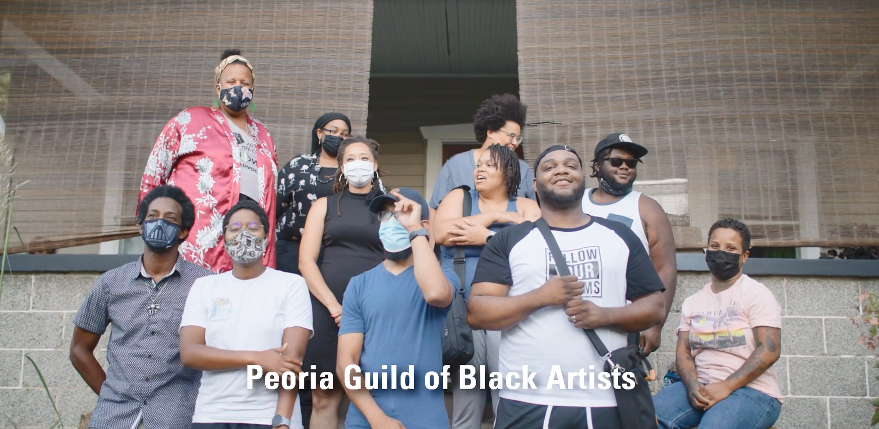 A group of people on steps outside a brick building. "Peoria Guild of Black Artists"