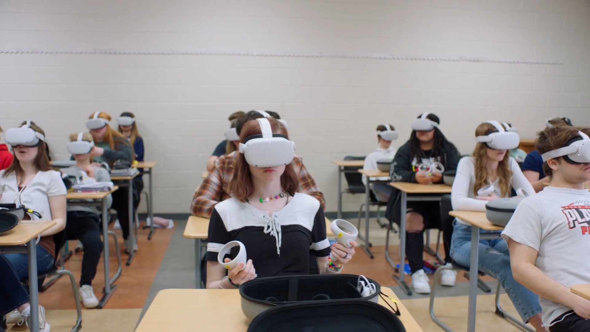 Classroom full of students sat at desks wearing VR headsets 