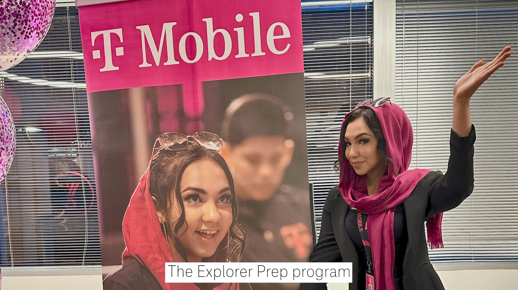 Daaniya standing next to a T-Mobile poster that features her.