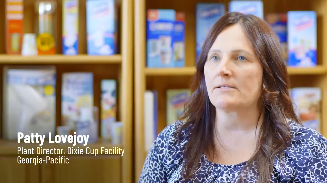 Patty Lovejoy, shelves of products behind her. 
