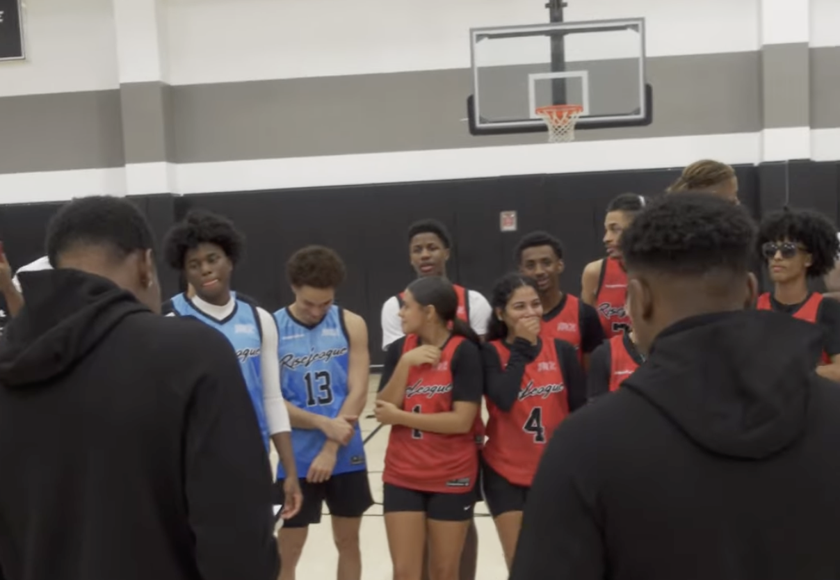 Two people reading a note to a basketball team 