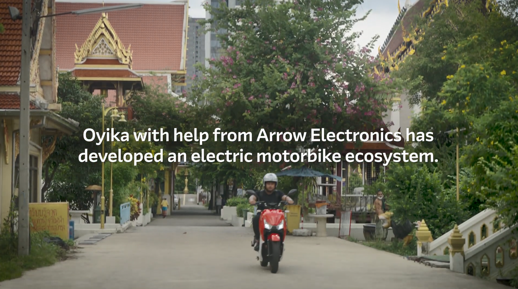 A person riding a motorbike down a street. "Oyika with help from Arrow Electronics has developed and electric motorbike ecosystem."