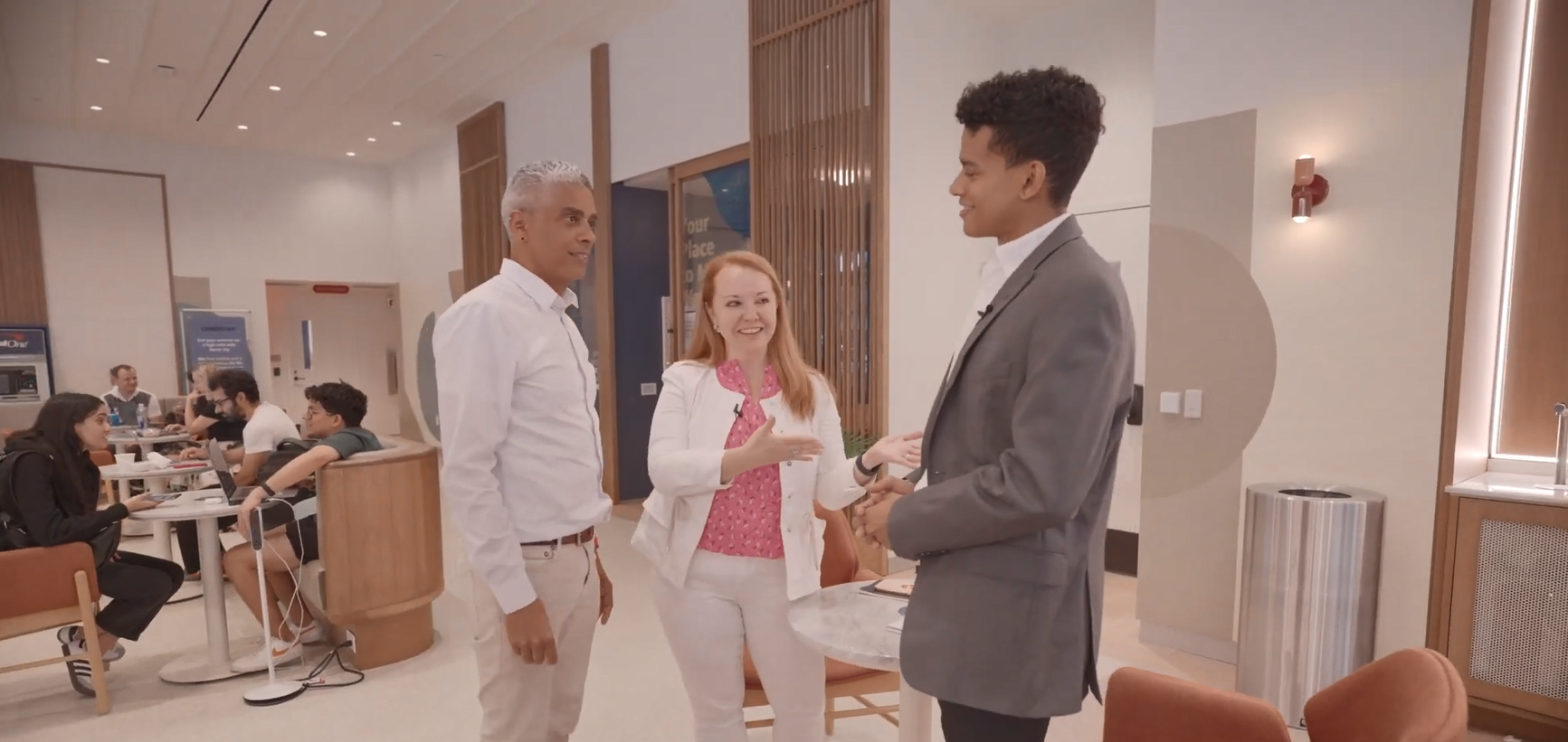 A central person introducing two others in a comfortable setting.