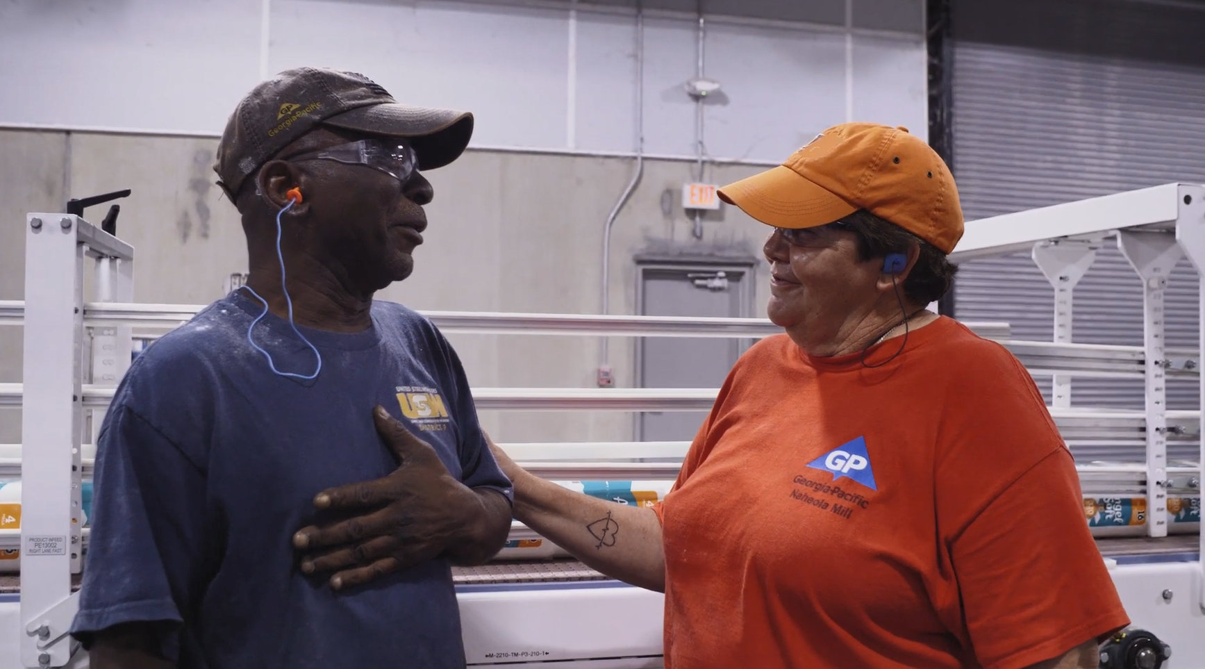 Amy and another employee, smiling in a warehouse.