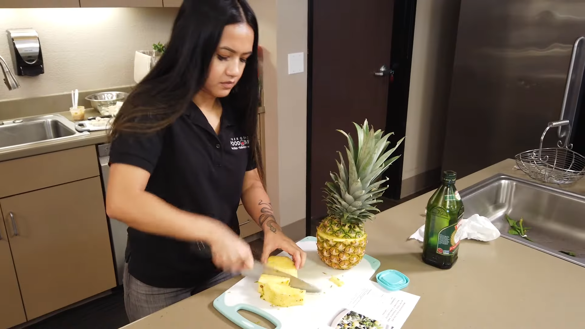A person chopping a pineapple on a chopping board 