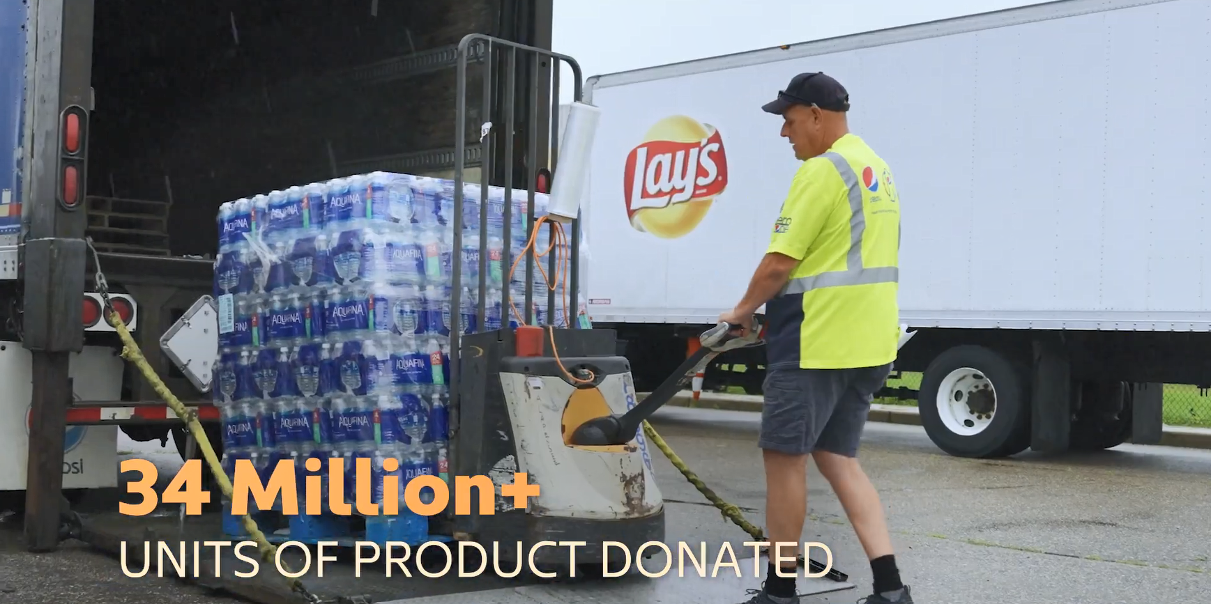 A person using a forklift to move pallets of bottled water.