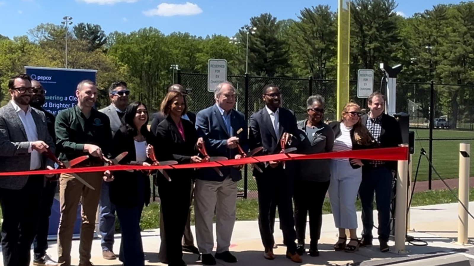 A group posed with scissors at a ribbon cutting ceremony.