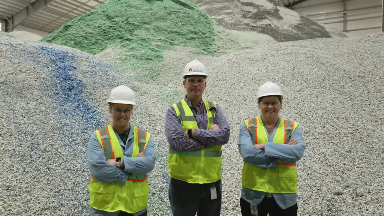 Three people stood inside a Recycling Facility