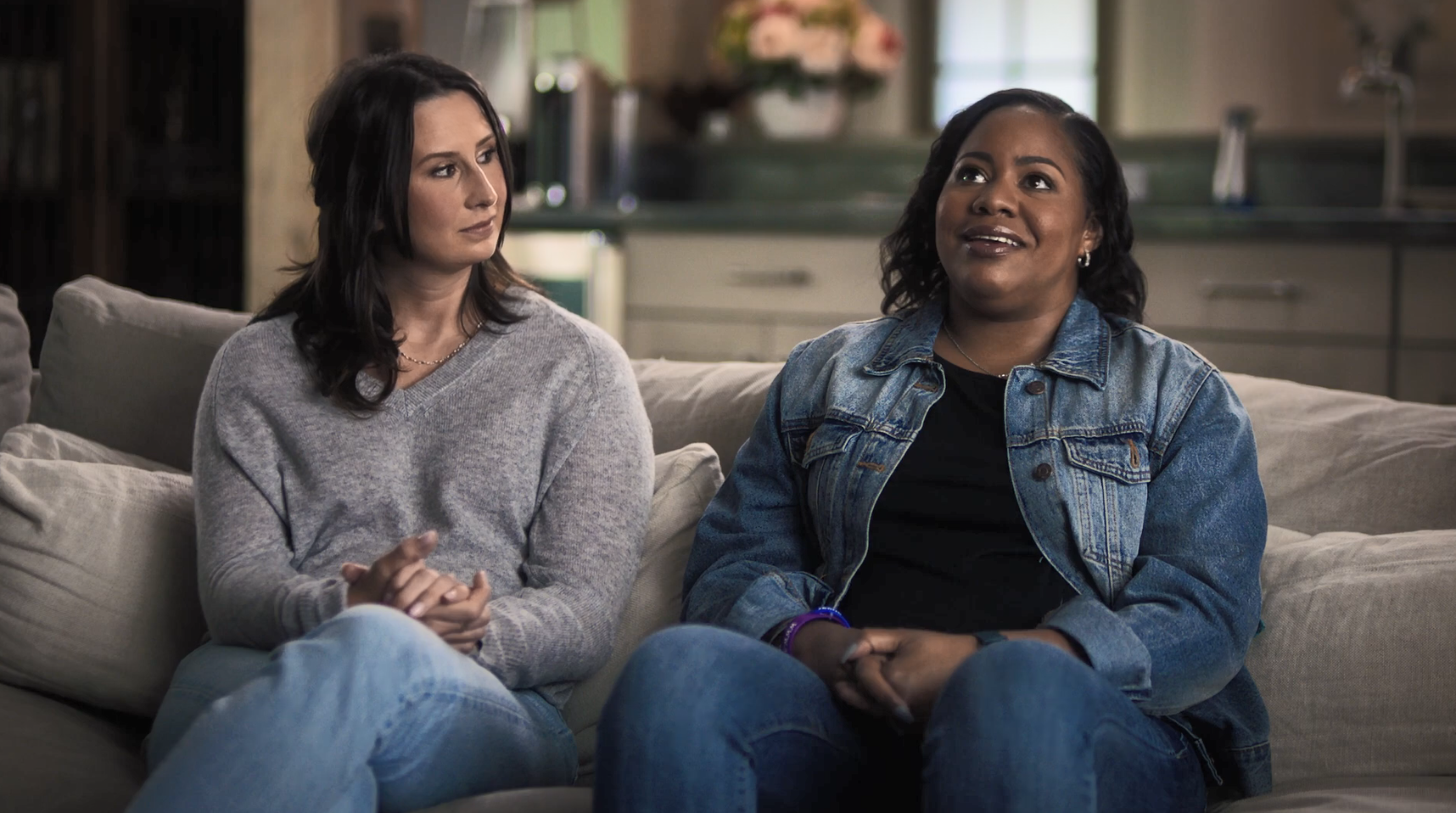 Two people seated on a couch.