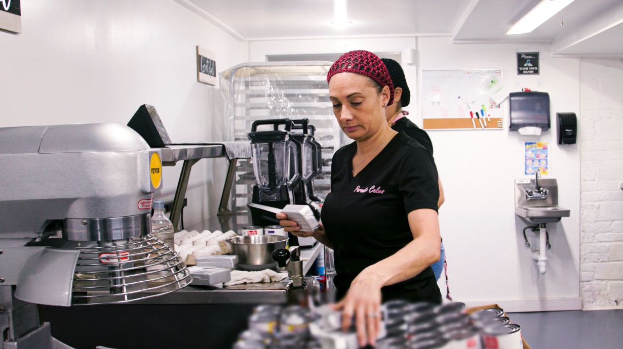 A person grabbing ingredients in a bakery setting.