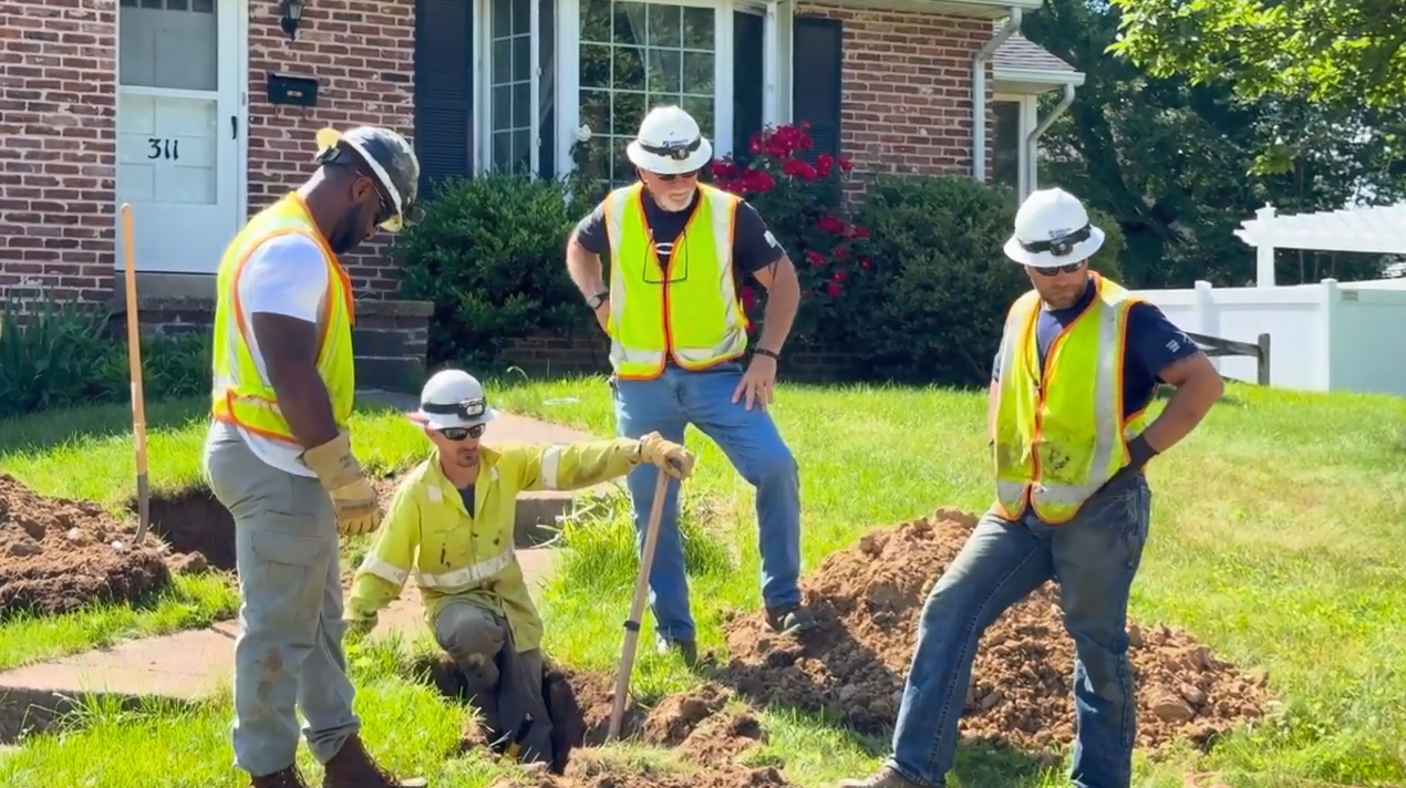 Larry Rohm and teammates digging in a residential yard.