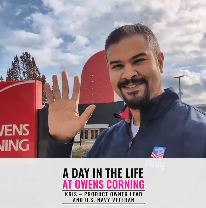Kris waving outside an Owens Corning building.
