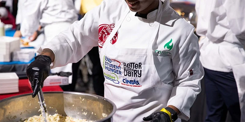 A chef cooking food in a big pot