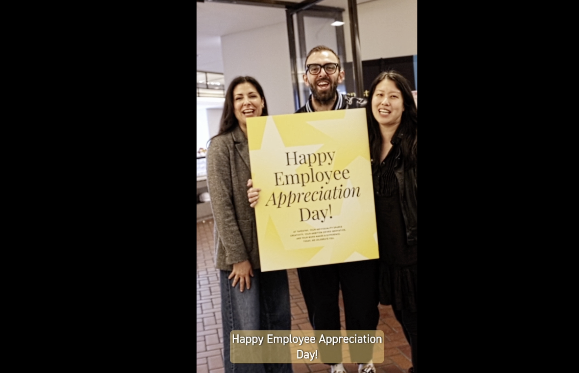 Tapestry employees holding employee appreciation day sign