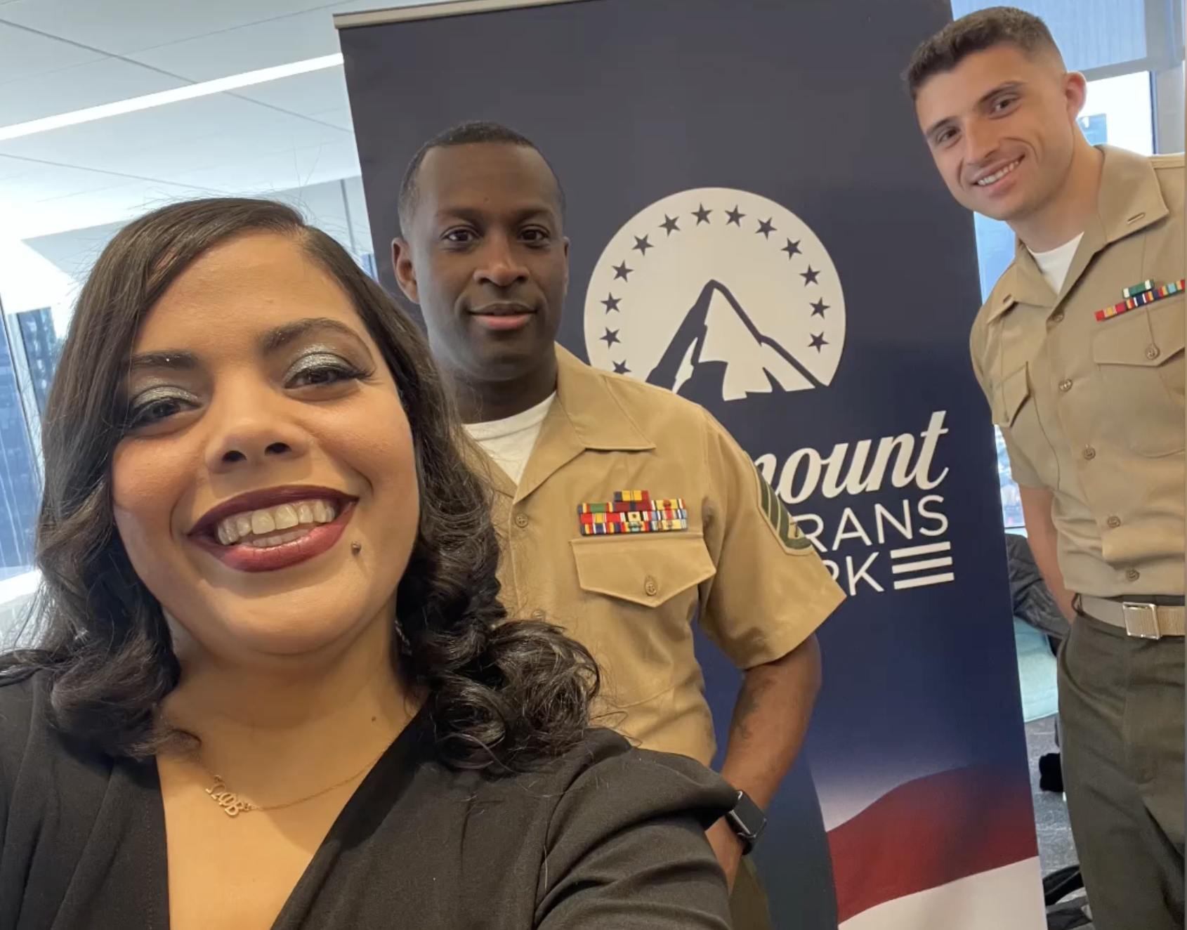 Service members standing in front of Paramount banner
