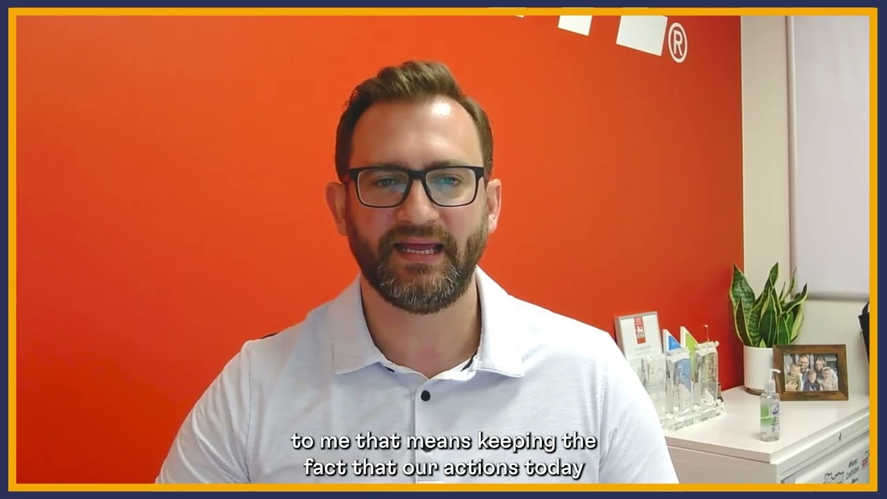 Someone shown talking in front of a red background