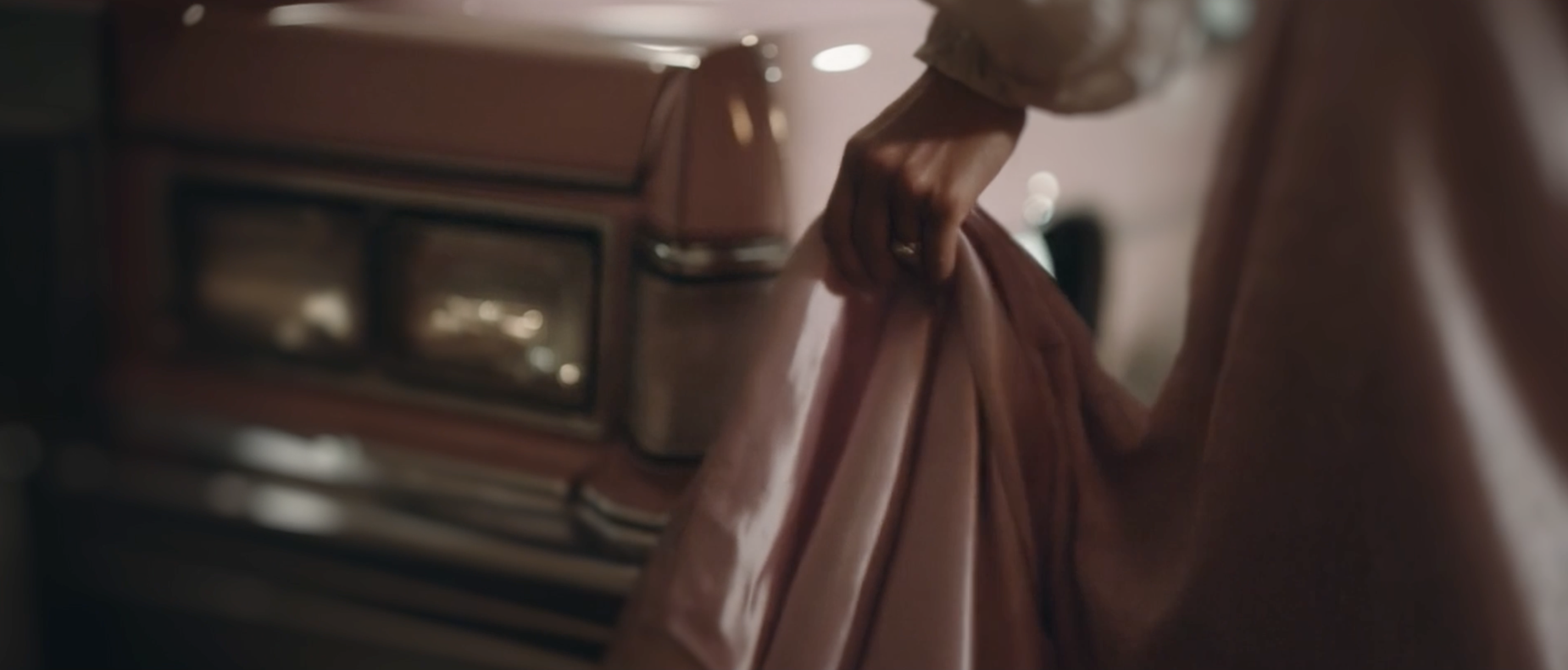 hand removing cover from pink car