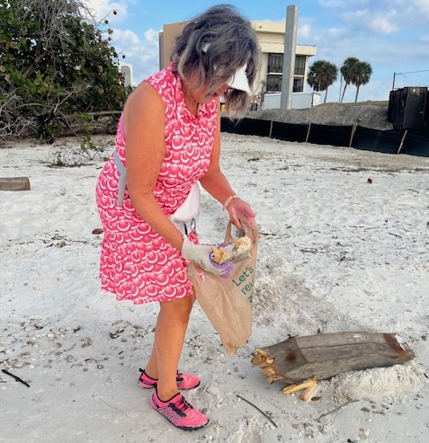 Chris picking up trash on the beach.