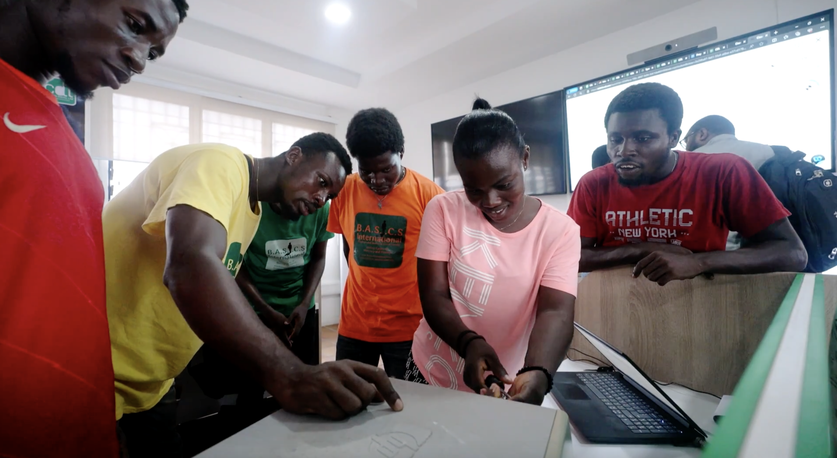 Several people grouped around computer together