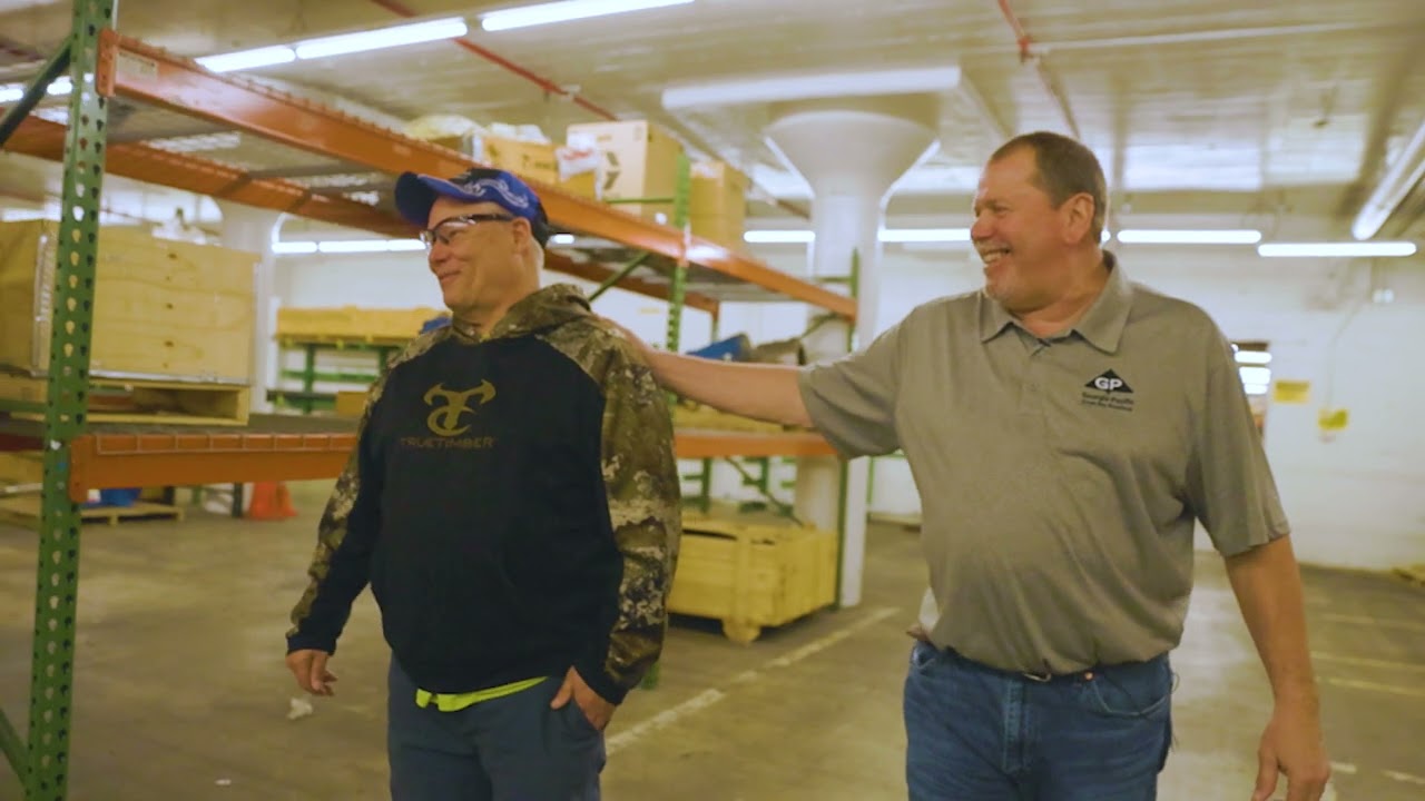 Two employees walking together in a warehouse