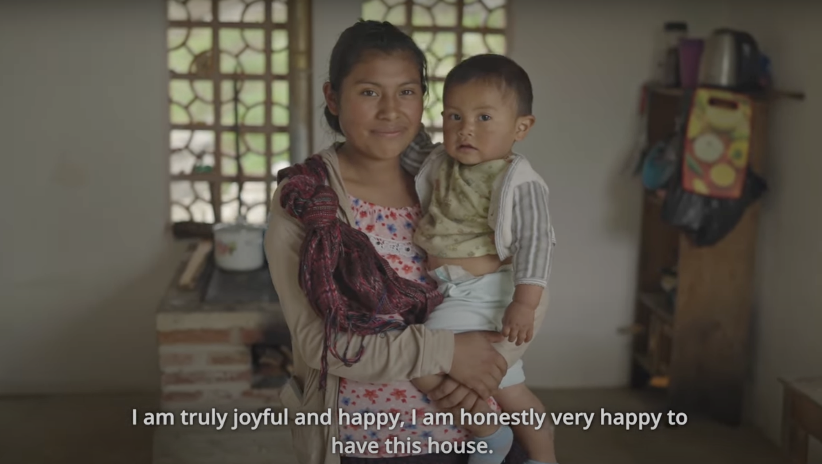 A mother holding her child in their new family home.