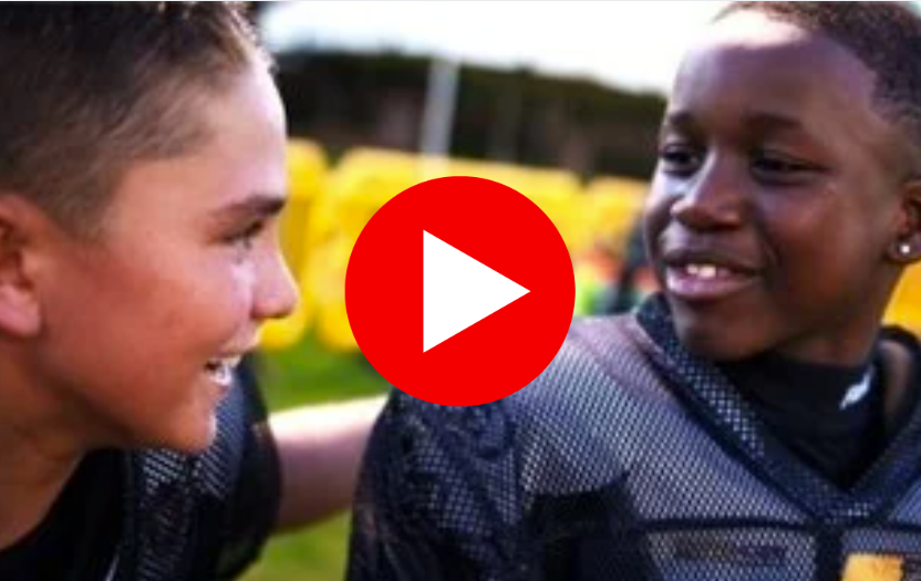 Two youth football players shown in their uniforms.