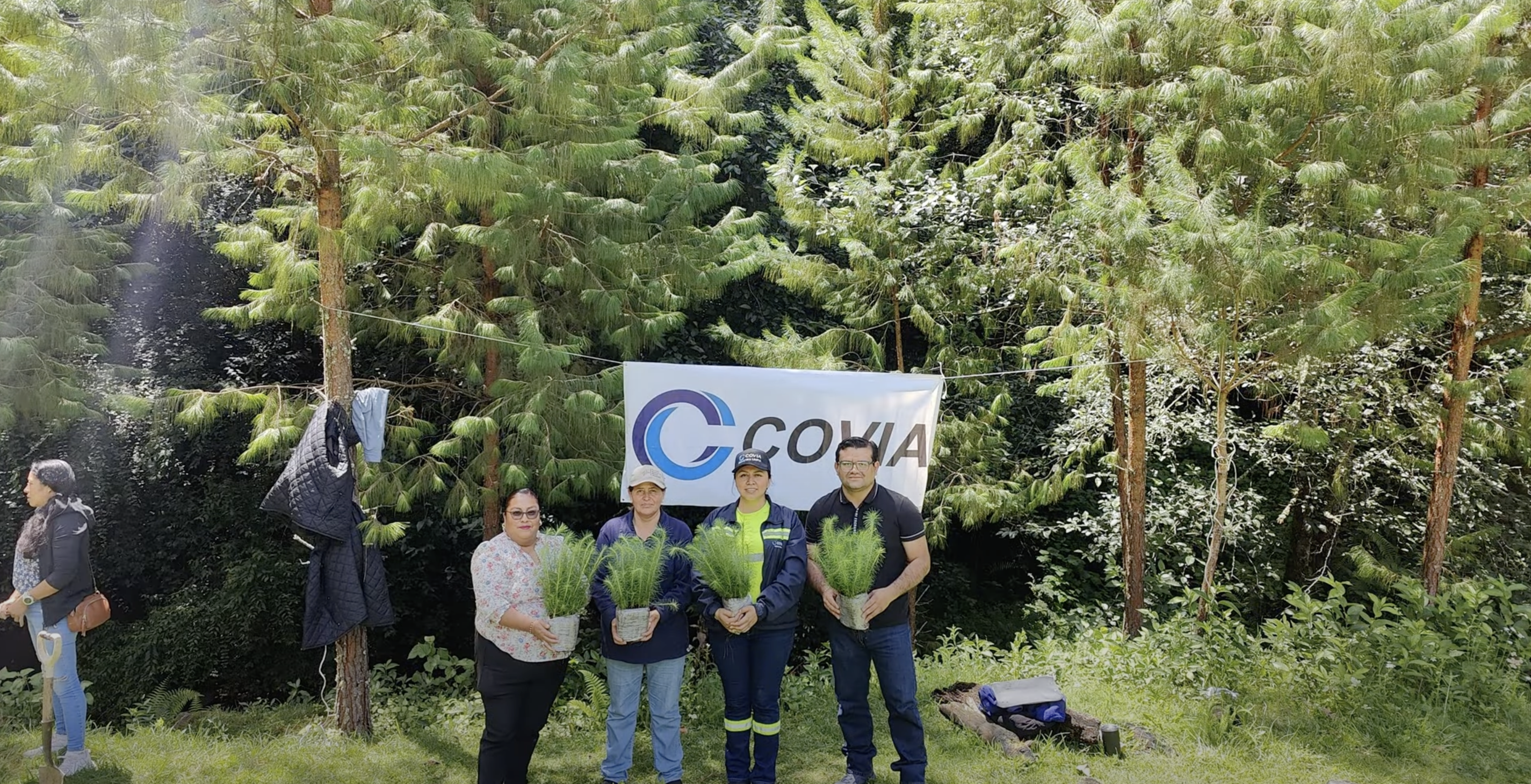 people holding plants in front of trees