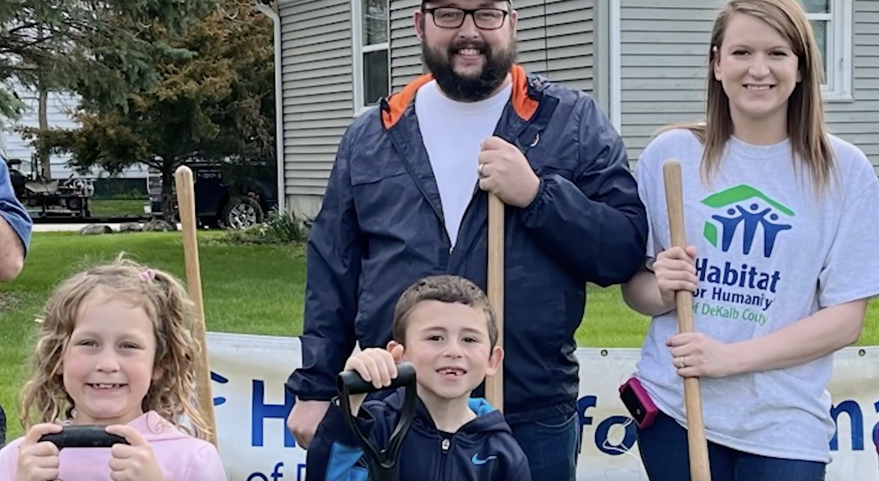 Family with two kids all holding shovels