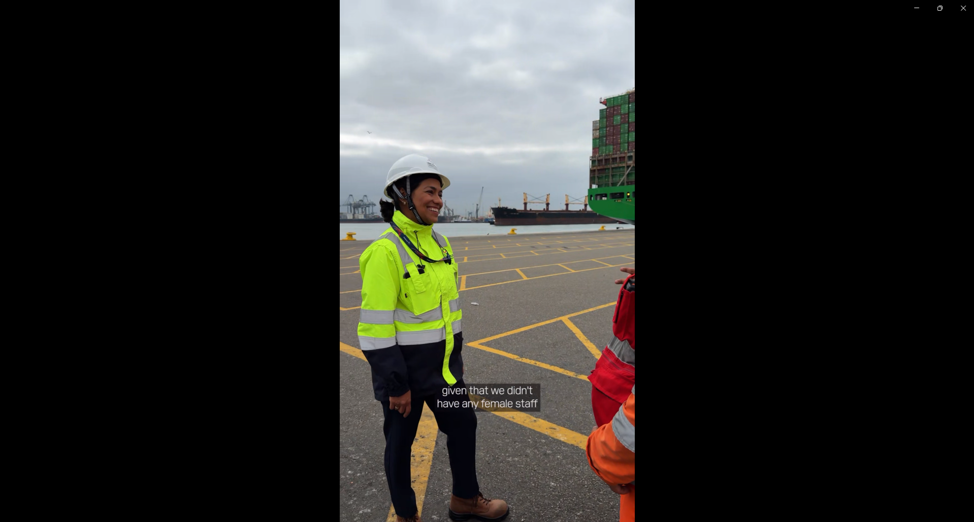 Cynthia Garrido, wearing a hard hat and high-visibility PPE, speaks with colleagues at DP World's container terminal in Callao, Peru