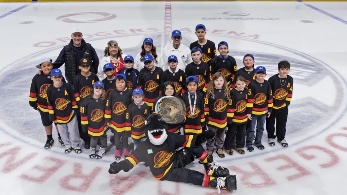 Kids posing on the ice with mascot