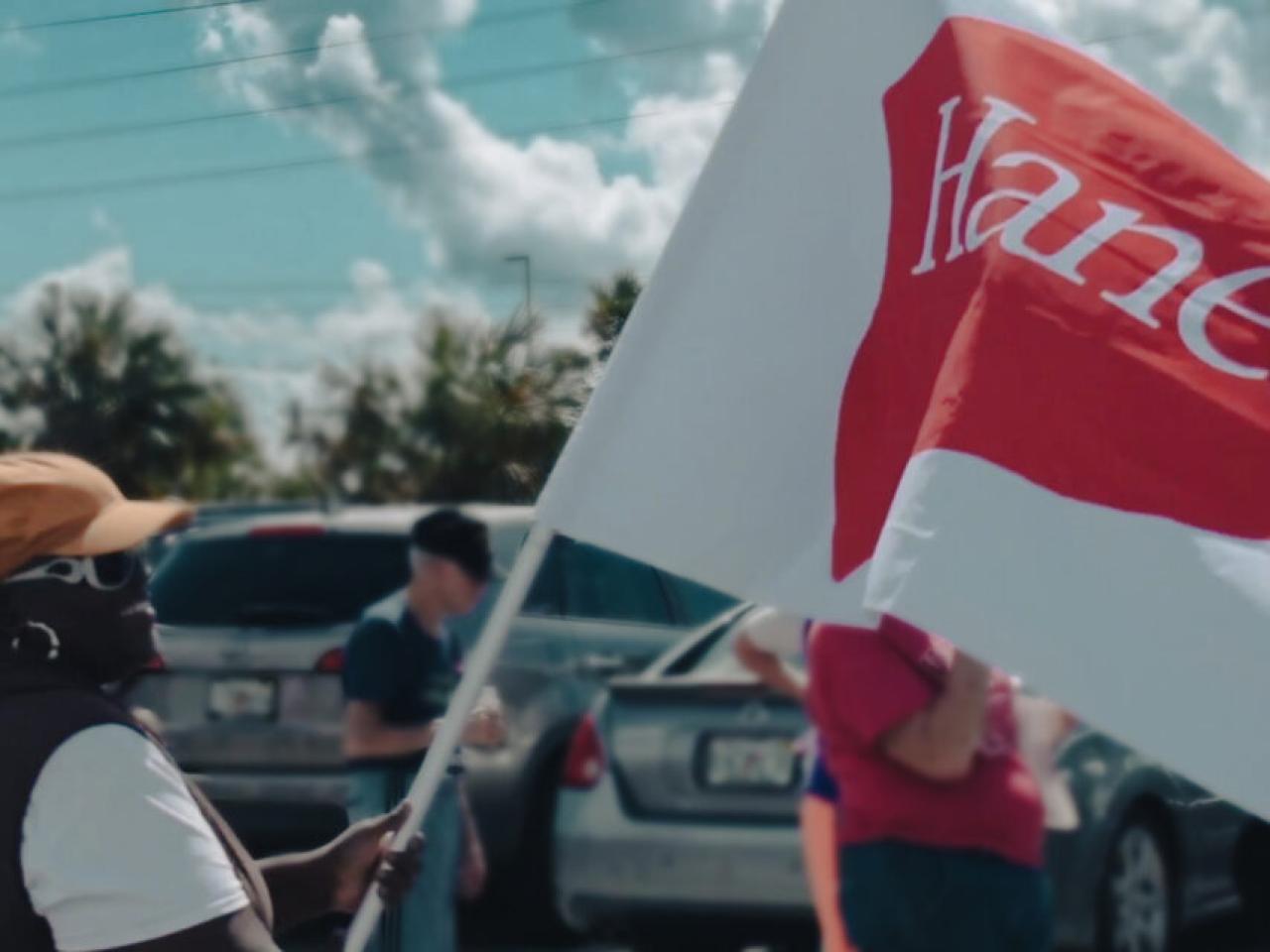 Woman holding a HanesBrands flag.