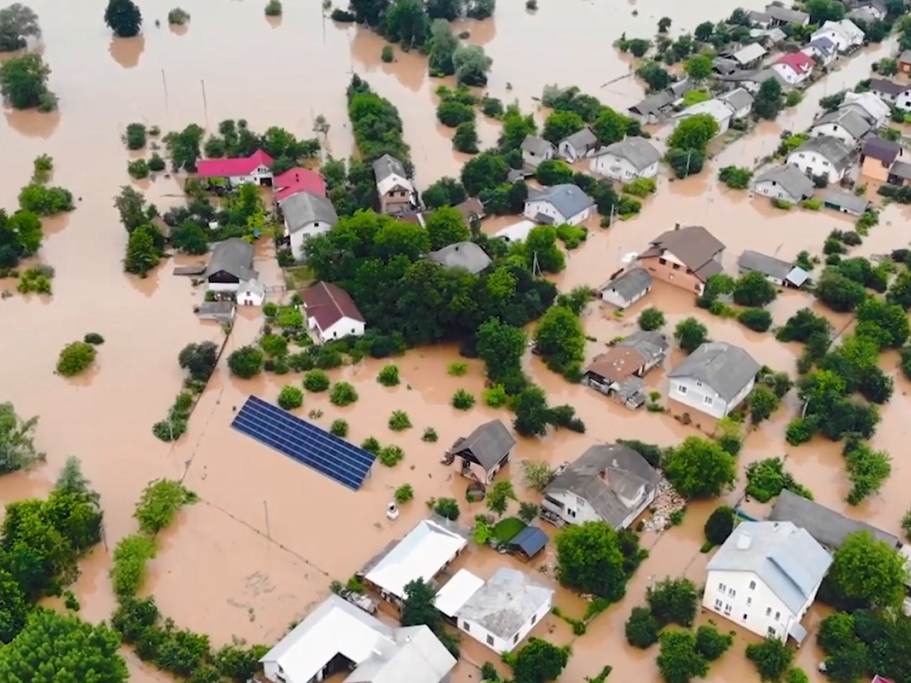 aerial view of a flooded neighborhood, many buildings fully or partially submerged.