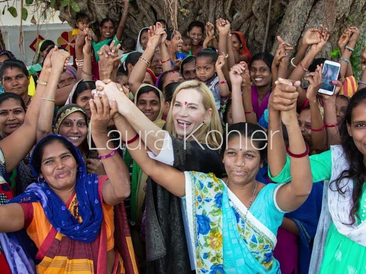 Laura Kohler holding raised hands with women