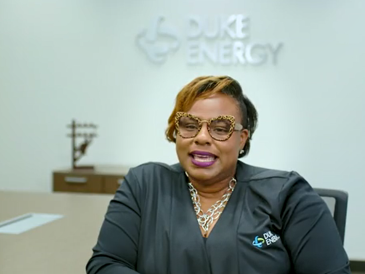 LaQuitta Gent, seated in a conference room. "Duke Energy" sign behind her.