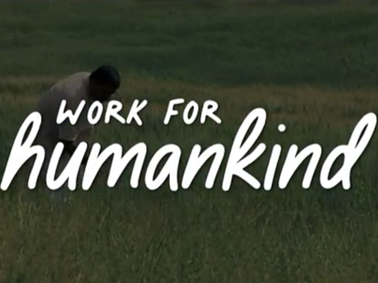Text "work for human kind" over a person working in a field