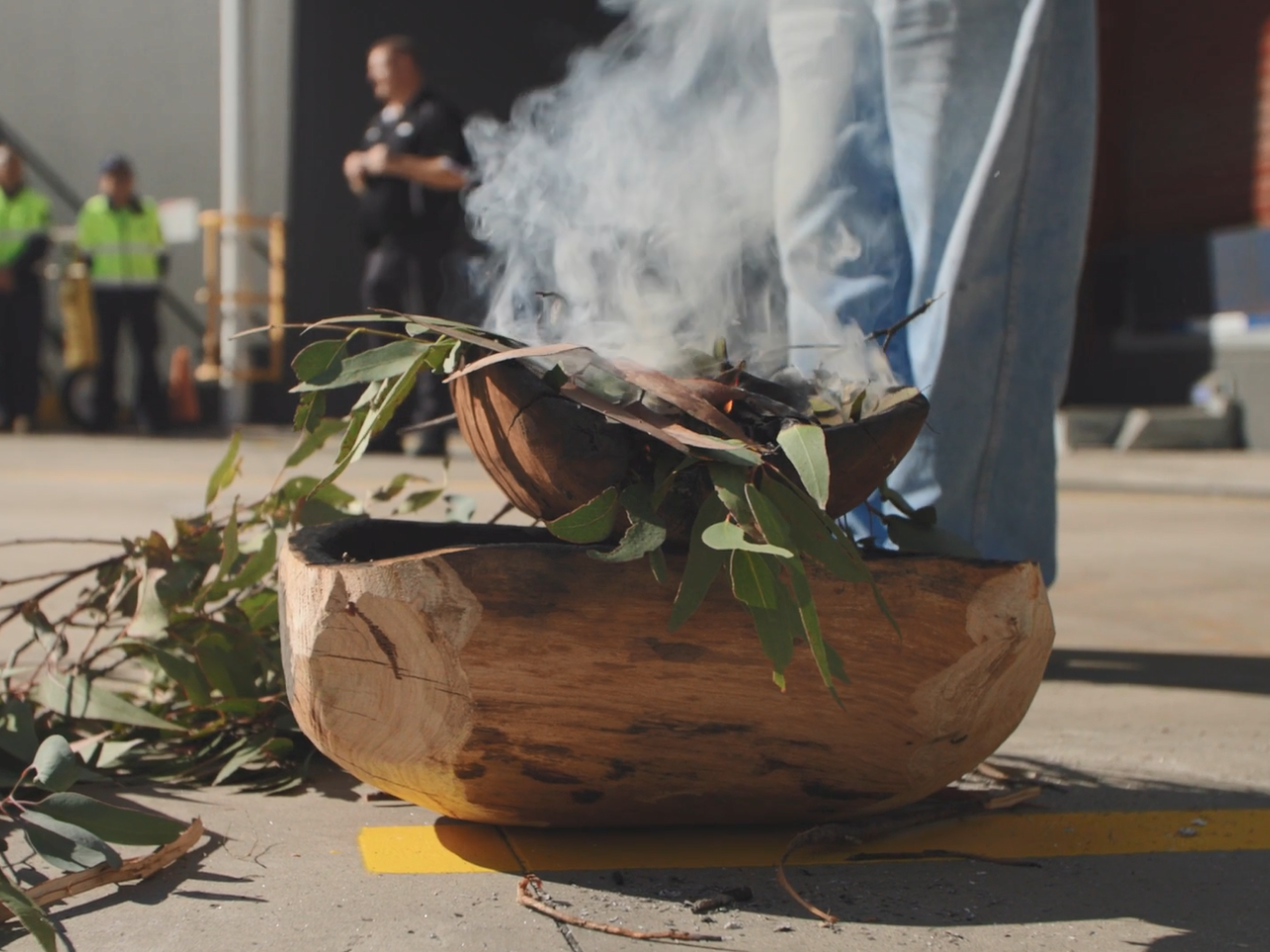 A person standing next to a ceremonial fire