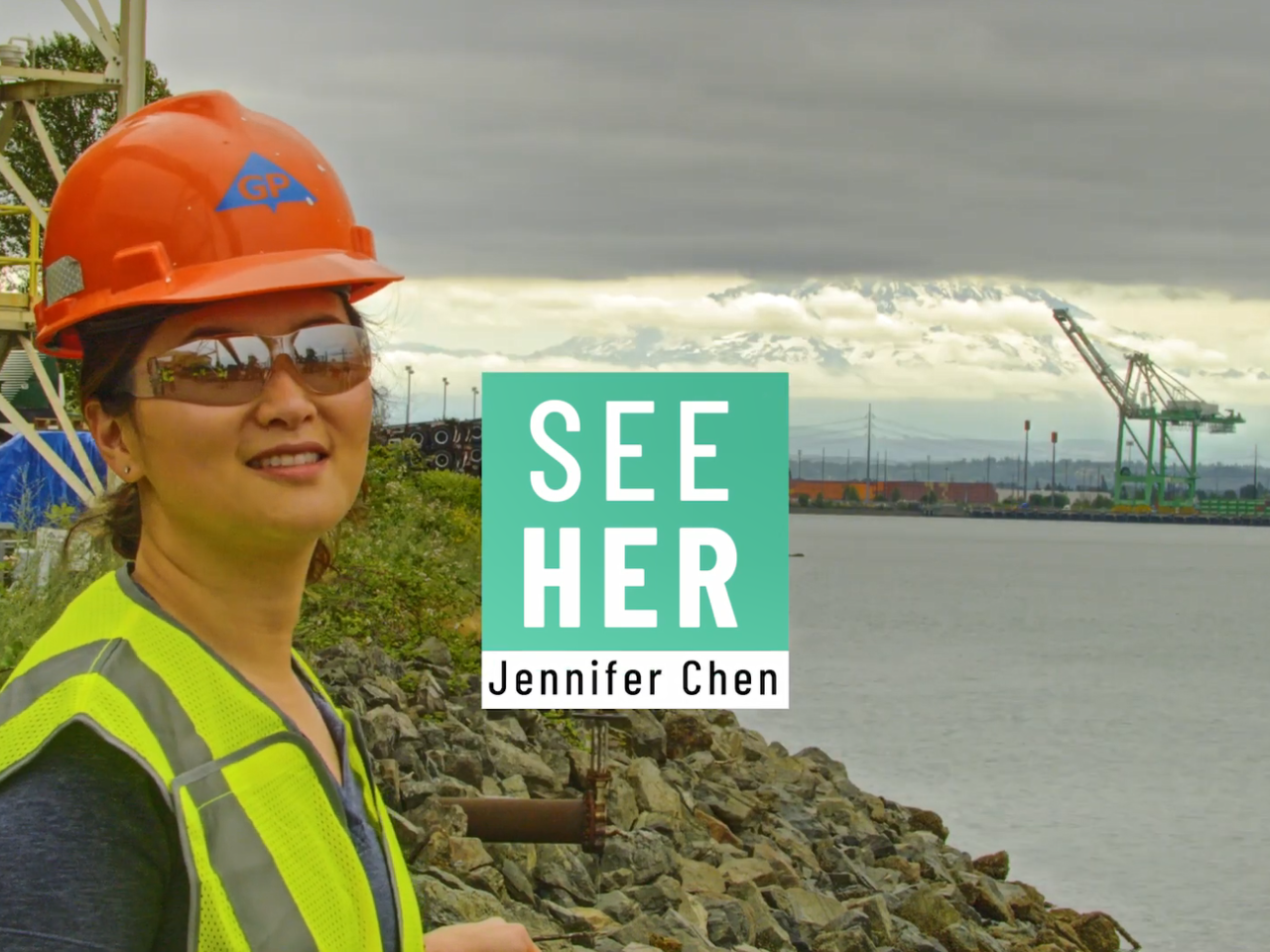 Jennifer Chen outside with a waterway and industrial machinery behind her. "SeeHer Jennifer Chen".