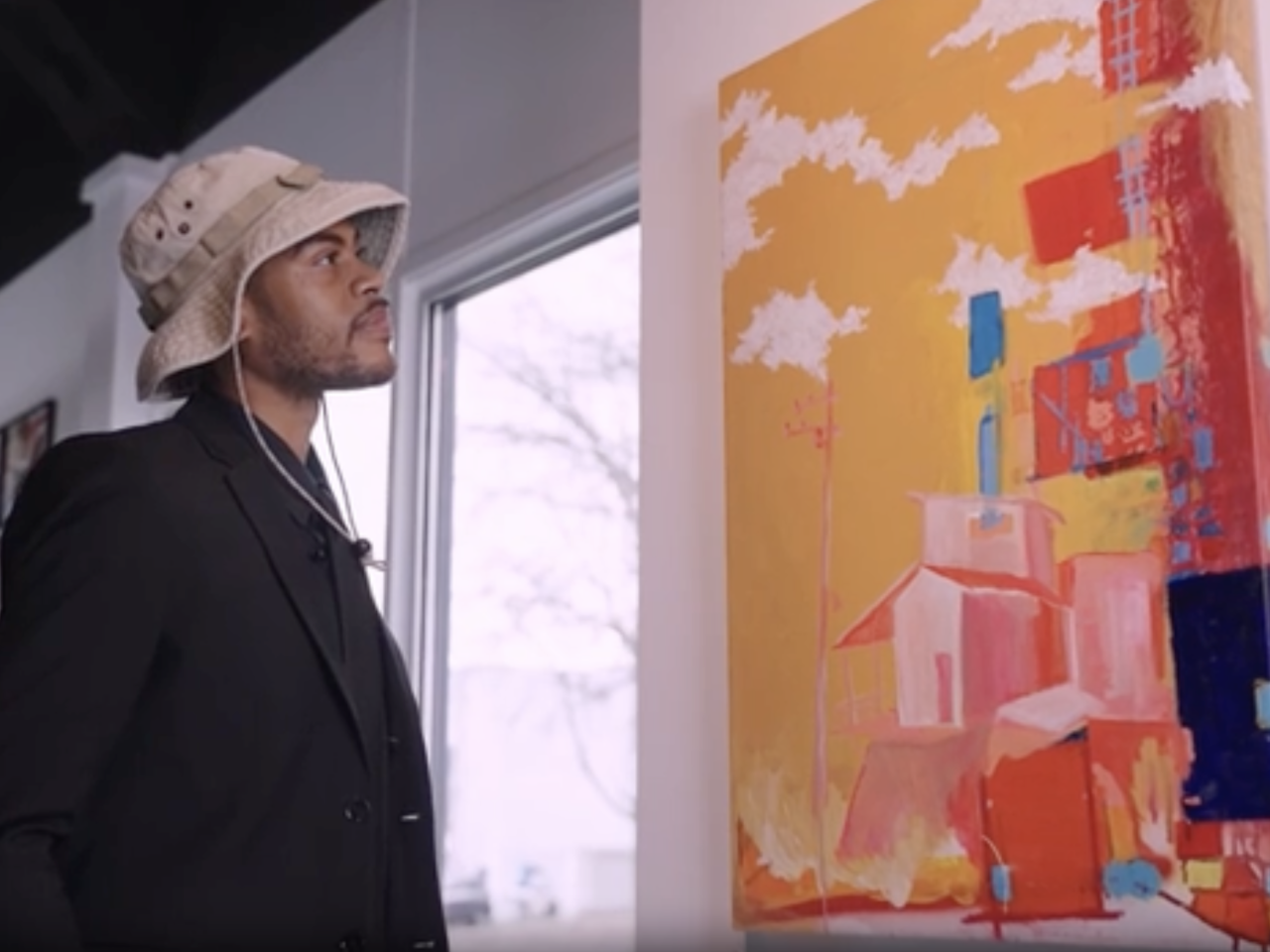 Justin Ellis looking at art hung up on the wall