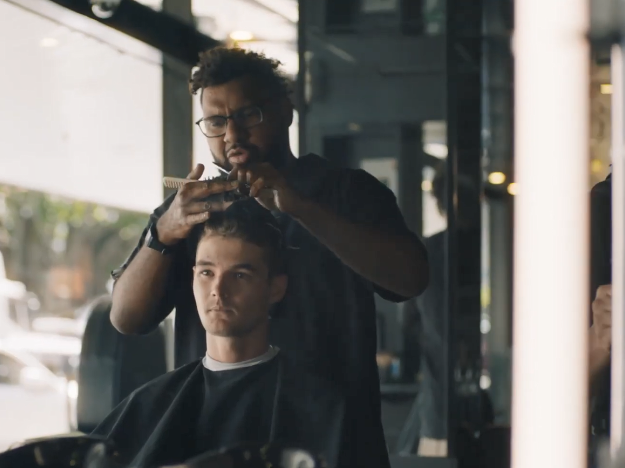 A person getting a haircut in a barber chair.