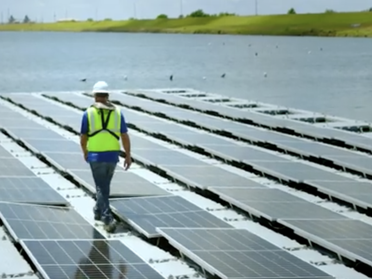 Worker walking on the floating solar array