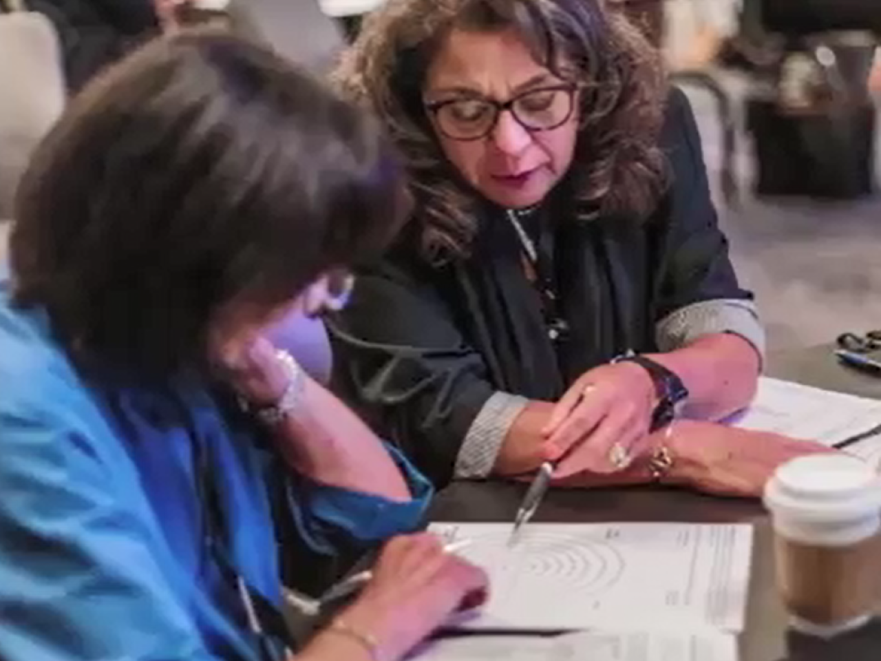 Two people looking at a diagram on a shared table.