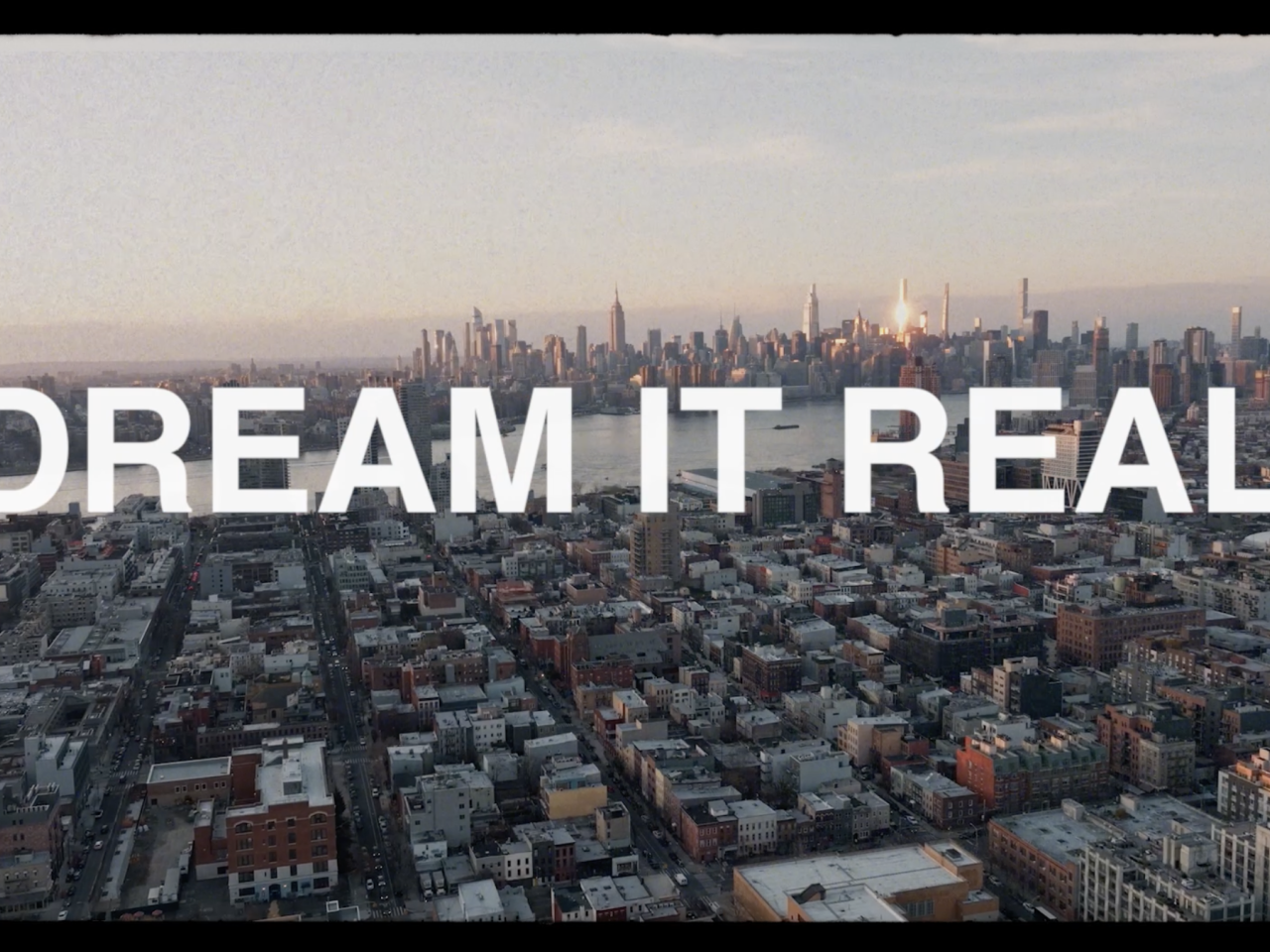 "DREAM IT REAL" over city skyline